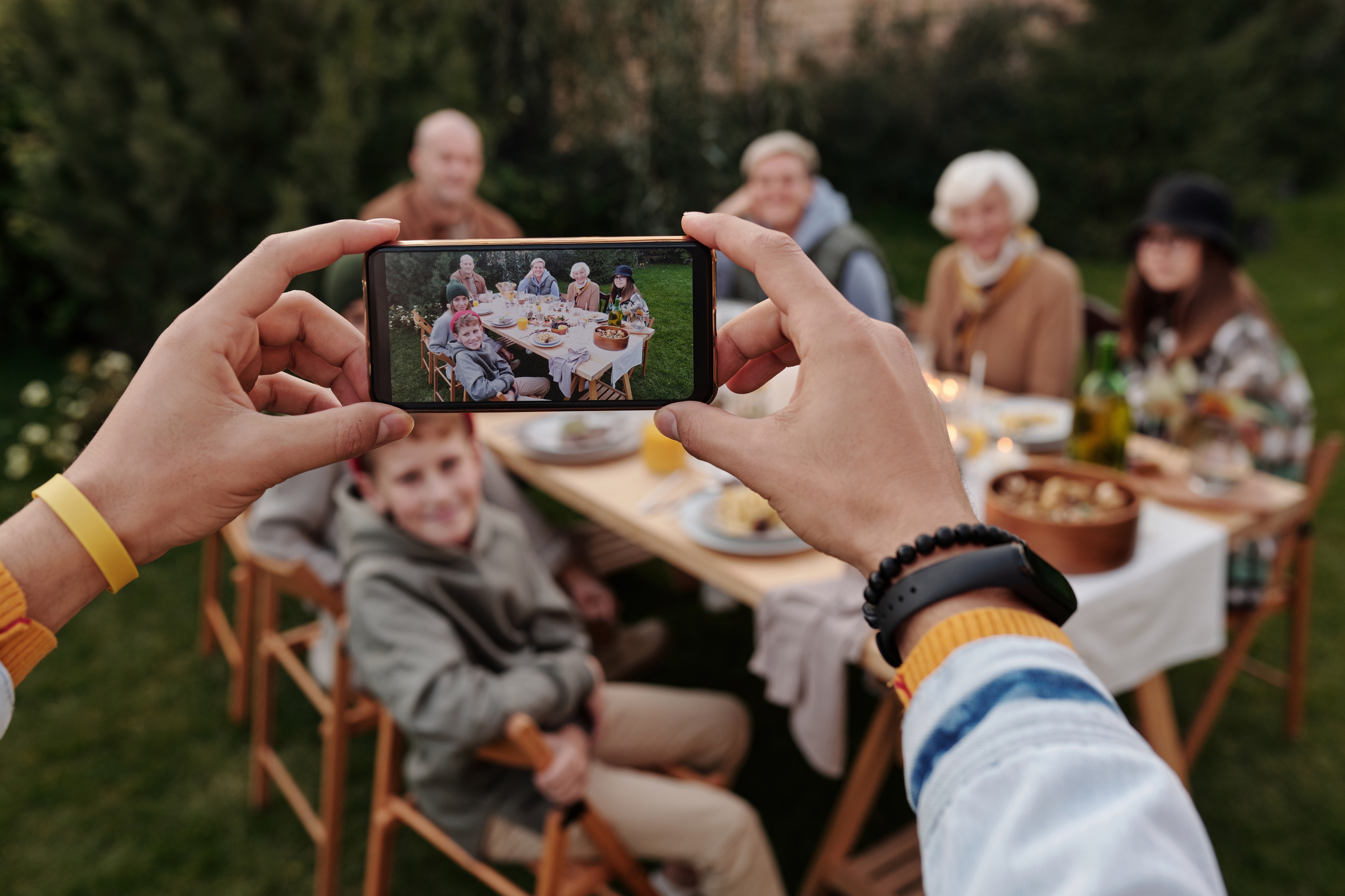 taking picture of family at table with smartphone